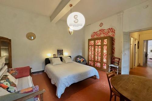 een slaapkamer met een bed en een tafel erin bij Studio Voltaire Arles Centre in Arles