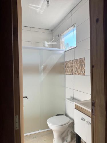 a white bathroom with a toilet and a sink at Park e Mar Studio quarto 1 in Penha