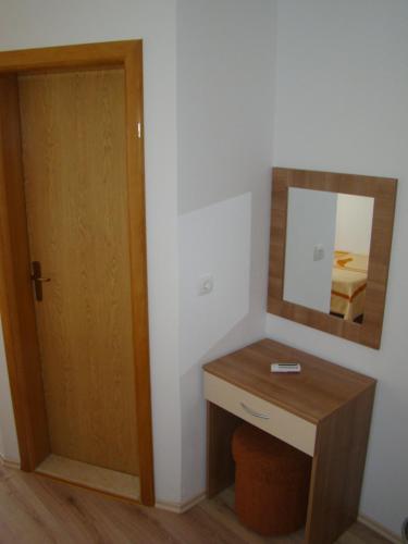 a bathroom with a mirror and a wooden door at Pansion Ivan in Međugorje