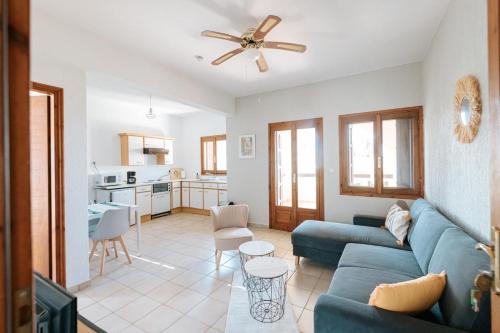 Una sala de estar con un sofá azul y una cocina. en Villa Eleonas, en Amaliapoli
