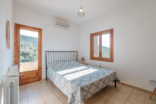 Un dormitorio con una cama y una ventana en Villa Eleonas, en Amaliapoli