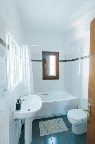 a white bathroom with a sink and a toilet at Villa Eleonas in Amaliapoli