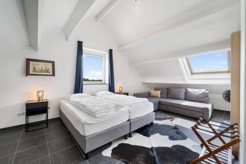 una camera da letto con un letto e un divano di Wijndomein Joris a Slenaken