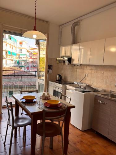 una cucina con tavolo, sedie e tavolo e una cucina con tavolo di Casa Arcobaleno a Sanremo