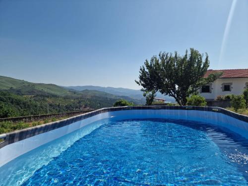 a swimming pool in a villa with mountains in the background at Casa Belavista no Geres by In'Canto Property Management in Ponte da Barca