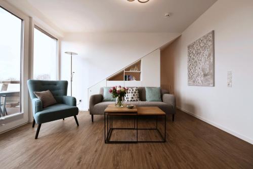 a living room with a couch and a chair and a table at Kirschgarten 17 in Kellenhusen