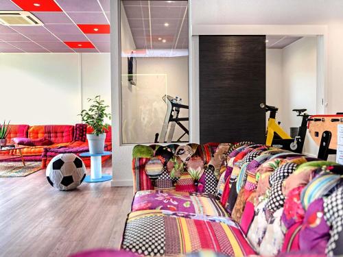 a living room with a couch and a soccer ball at ibis budget Strasbourg Sud Illkirch in Geispolsheim