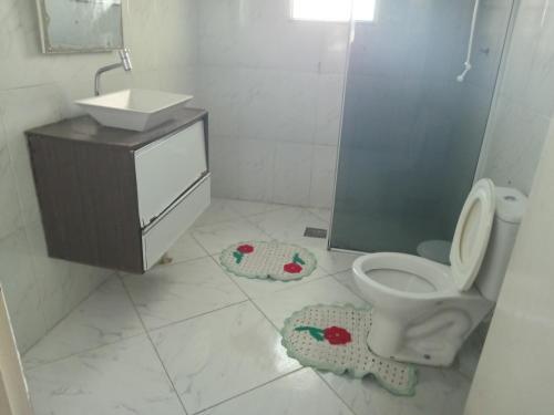 a bathroom with a toilet and a sink and a shower at Casa Neia Castro com Piscina e garagem perto da Basilica in Aparecida