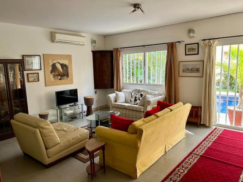 a living room with two couches and a tv at Two bedroom villa with private swimming pool and garden in Almadies in Dakar