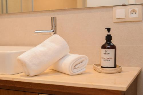 um lavatório de casa de banho com uma garrafa de sabão e uma toalha em Relax & Sea View à 2 Pas de la Marina em Tânger