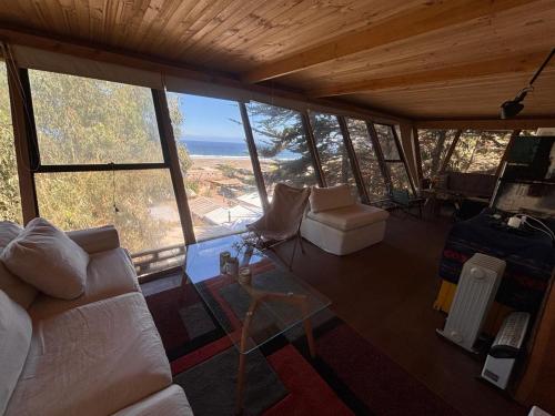 un soggiorno con un divano e un tavolo di vetro di Cabaña Calma a Puertecillo