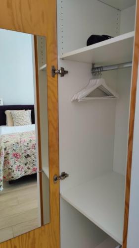 un placard avec un miroir à côté d'un lit dans l'établissement b&b les invités, à Bruges