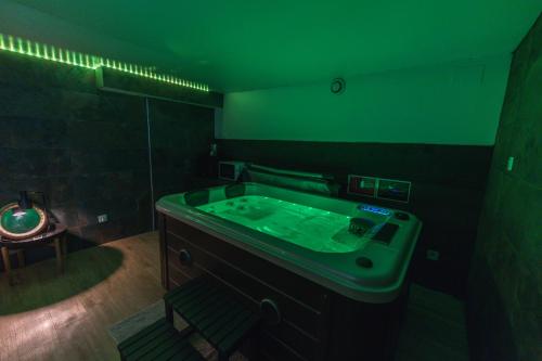 a bathroom with a green tub in a room at Suite Tentation avec Jacuzzi in Châteauneuf-lès-Martigues