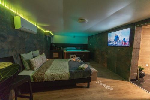 a bedroom with a bed and a tv on the wall at Suite Tentation avec Jacuzzi in Châteauneuf-lès-Martigues
