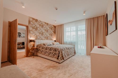 Un dormitorio con una cama y una ventana grande. en Villa Garden Apartments, en Poprad