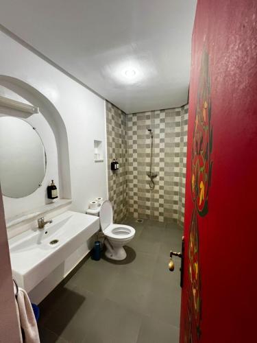 a bathroom with a white sink and a toilet at Hôtel LAKASBAH Ait Ben Haddou in Aït Benhaddou