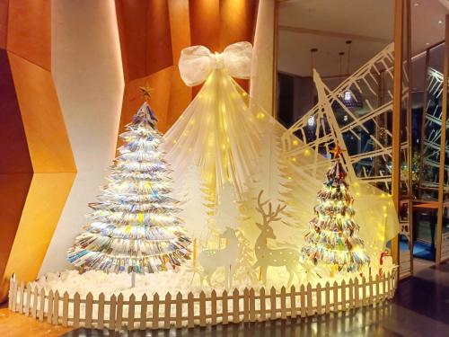 a christmas display with two christmas trees in a window at Bay View Halong Homestay Panoramic Bay View Luxury Apartment in Ha Long