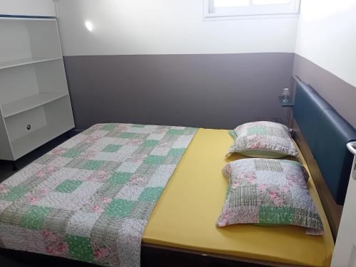 a small bedroom with a bed with two pillows on it at sci careffour dugomier in Le Moule
