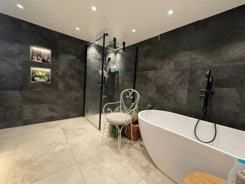 Kungsbacka Företagsbostad في كونغْسباكا: حمام كبير مع حوض استحمام ودش