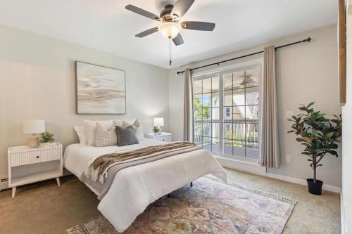 Un dormitorio con una cama y un ventilador de techo. en Designer home sleeps 10 winter water views, en South Portland