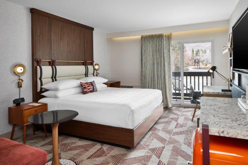 パークシティにあるHotel Thaynes, Park City, a Tribute Portfolio Hotelのベッドとバルコニー付きのホテルの部屋
