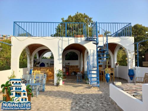 a patio with blue chairs and a staircase at Nubian Lotus in Aswan