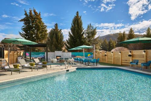 パークシティにあるHotel Thaynes, Park City, a Tribute Portfolio Hotelのパティオ家具とパラソル付きのスイミングプールを提供しています。