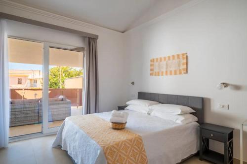 a bedroom with a large bed and a balcony at I Centenari Longevity Rooms in Lotzorai