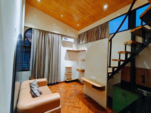 uma sala de estar com um sofá e uma escada em Joey's By The Ganges em Rishikesh