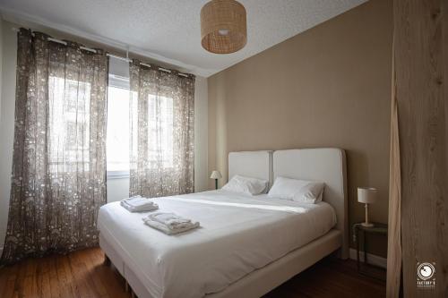 a bedroom with a white bed and a large window at Les Pingouins de la Gare in Brest