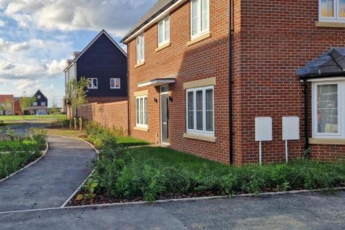 a brick house with a road next to it at Peterborough - House - Sleeps 8 - Parking - Garden in Peterborough