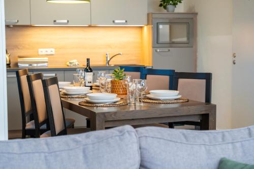 a dining room table with plates and wine glasses at Lipno Stories in Lipno nad Vltavou
