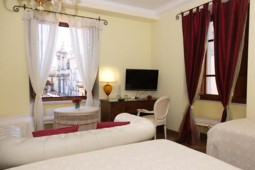 Room & Breakfast La Dimora في سولمونا: غرفة معيشة بها أريكة بيضاء وتلفزيون