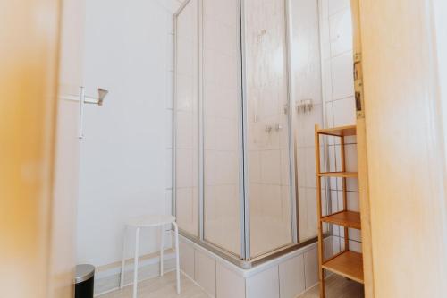 a glass shower in a bathroom with a stool at Geräumige Ferienwohnung nah am Rhein & Marktplatz in Boppard