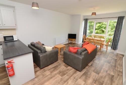een woonkamer met twee banken en een keuken bij Dunaras Holiday Village in Galway