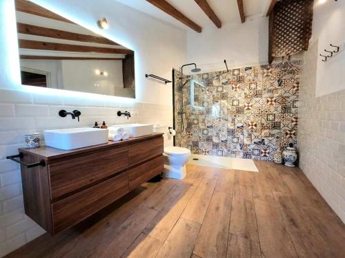 een badkamer met een wastafel, een toilet en een douche bij Casa Ca'n Bernat in Santanyi