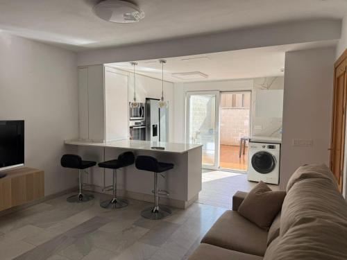 een woonkamer met een bank en een keuken bij Casa Familiar Atarfe in Atarfe