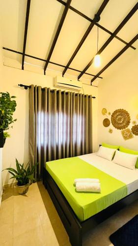 a bedroom with a green bed in a room at Little J villa in Dickwella