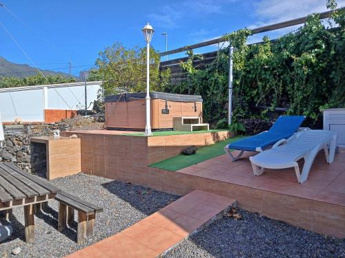 埃尔帕索Bungalow Los Guanches 3的露台上摆放着一张蓝色长椅和一个烧烤架