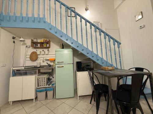 een keuken met een koelkast en een tafel met een trap bij Miniloft scala blu in Milaan
