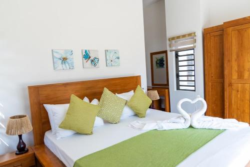 a bedroom with a white bed with a heart pillow at Summer Palms Villa in Flic-en-Flac