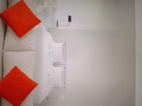 een witte koelkast met twee oranje kussens erop bij Star light hotel in Monterrey