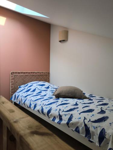 Un dormitorio con una cama con un edredón azul. en Appartement résidence historique centre de Vernon, en Vernon