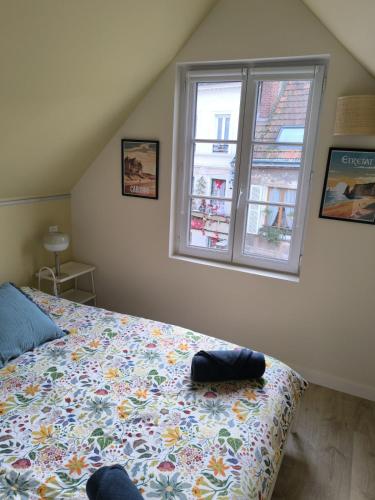 Dormitorio con cama con manta estampada de flores en Appartement résidence historique centre de Vernon, en Vernon