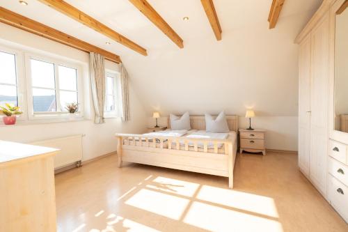 una camera da letto con un letto e due finestre di Haus "Zur Düne" a Norddorf