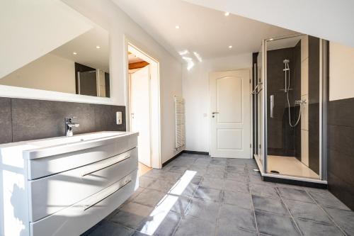 un bagno con lavandino e doccia di Haus "Zur Düne" a Norddorf