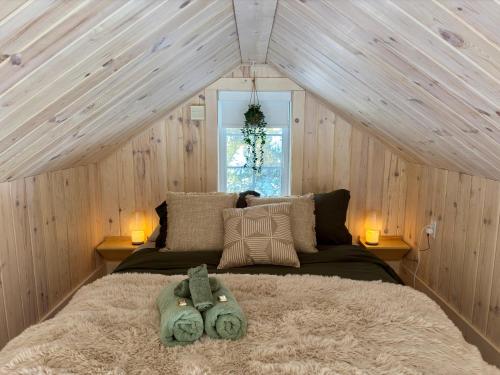 une chambre avec un grand lit dans une pièce aux murs en bois dans l'établissement Pur Nature Garthby et Sauna, à Saint-Gérard