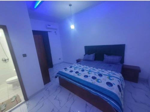 a bedroom with a bed with a blue comforter at Superetoile in Rufisque