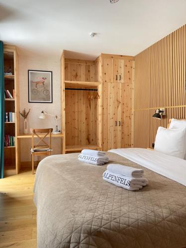 Alpenfels Apartments - Zwieselstein في سولدن: غرفة نوم بها سريرين مع مناشف عليهما