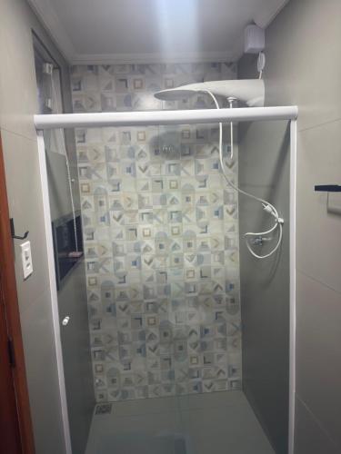 a shower with a glass door in a bathroom at Suíte Doce Recomeço da Alice in Arraial do Cabo